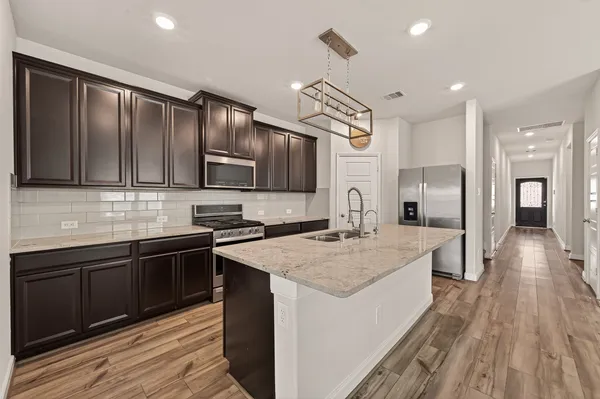 a kitchen with stainless steel appliances granite countertop a sink stove and refrigerator