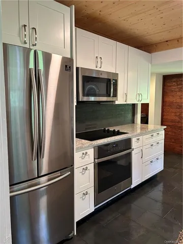 a kitchen with stainless steel appliances and white cabinets