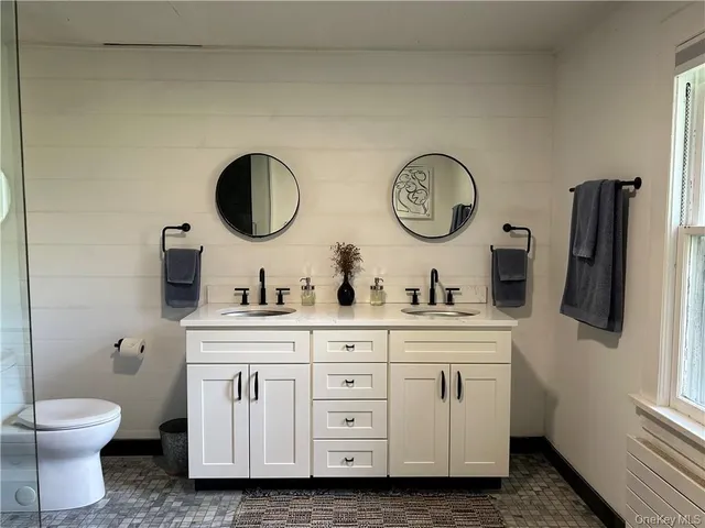 a bathroom with a toilet a sink and a mirror