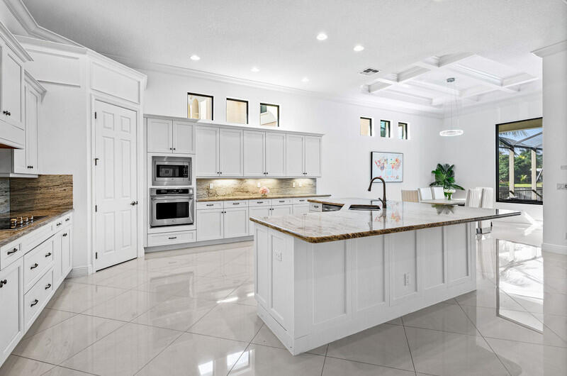 12153 Boca Reserve Lane Boca Raton, FL 33428 - Photo 6 of 35 a kitchen with stainless steel appliances kitchen island granite countertop a sink and cabinets