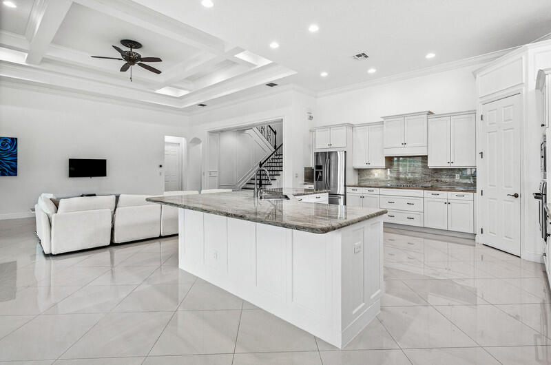 12153 Boca Reserve Lane Boca Raton, FL 33428 - Photo 7 of 35 a kitchen with kitchen island granite countertop a sink a counter top space appliances and cabinets