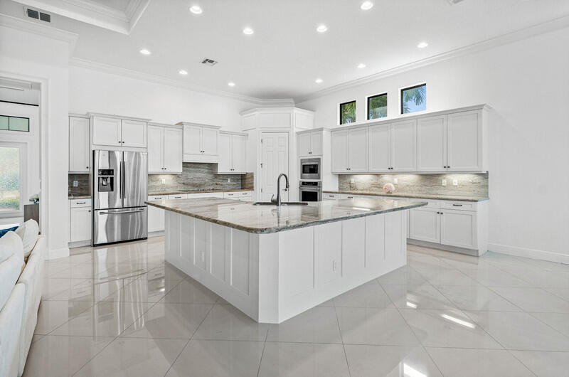 12153 Boca Reserve Lane Boca Raton, FL 33428 - Photo 9 of 35 a kitchen with stainless steel appliances granite countertop a sink counter space cabinets and a large window
