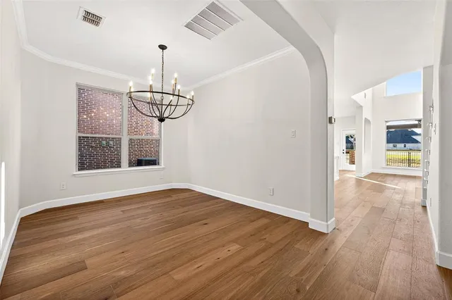 a view of a room with wooden floor window and chandelier
