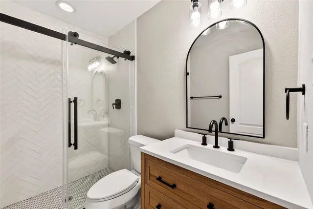 a bathroom with a sink a toilet and shower