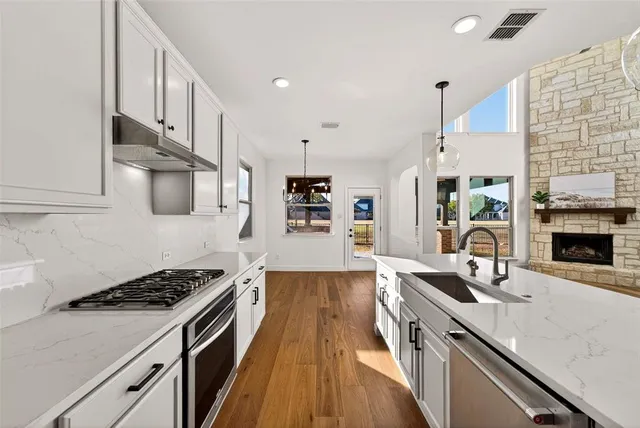 a kitchen with stainless steel appliances a stove sink and cabinets
