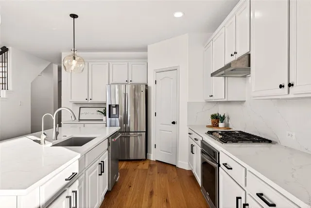 a kitchen with kitchen island stainless steel appliances a sink stove and refrigerator
