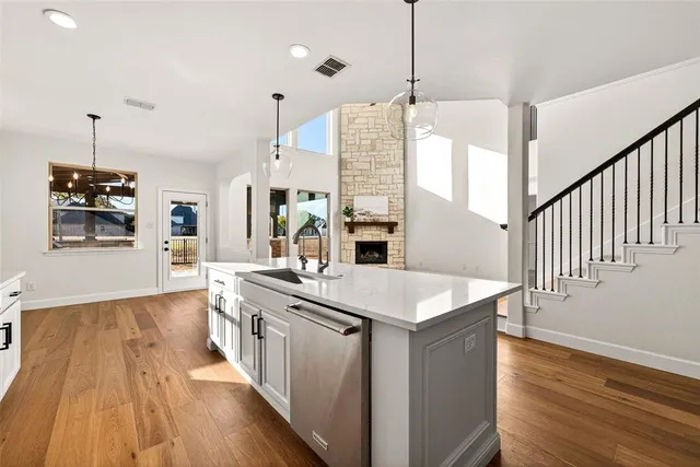 a very nice looking room with wooden floor and a kitchen view