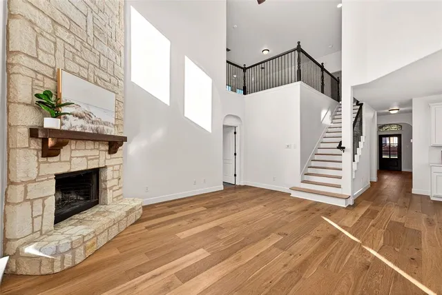 a view of a livingroom with wooden floor fireplace and stairs