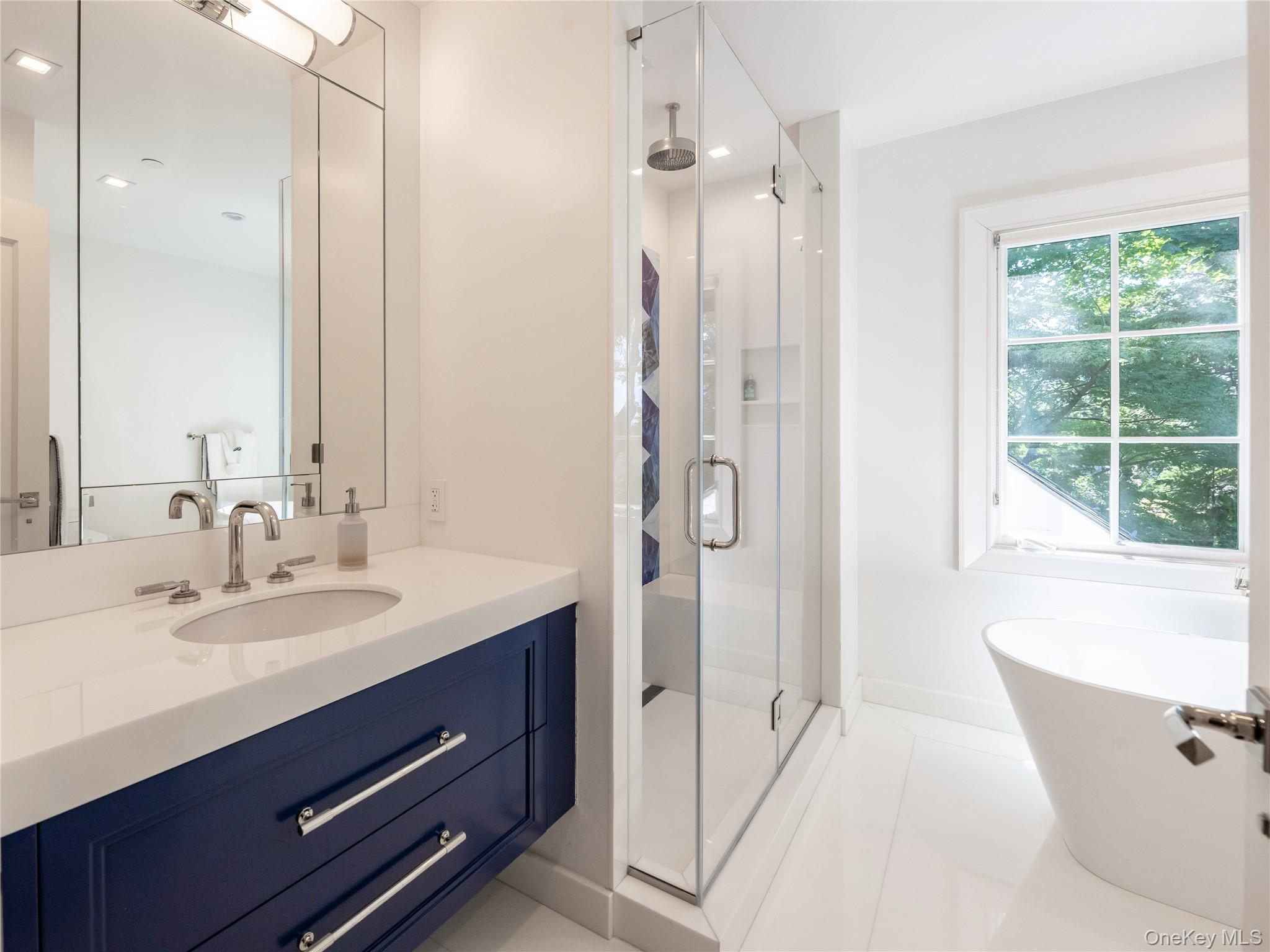 16 Ridge Drive East Great Neck, NY 11021 - Photo 37 of 50 Full Bathroom featuring a shower stall, vanity, a soaking tub, and light tile patterned floors