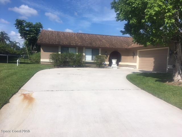 1302 Cherry Hills Road Northeast Palm Bay, FL 32905 - Photo 1 of 24 a front view of a house with a yard and garage