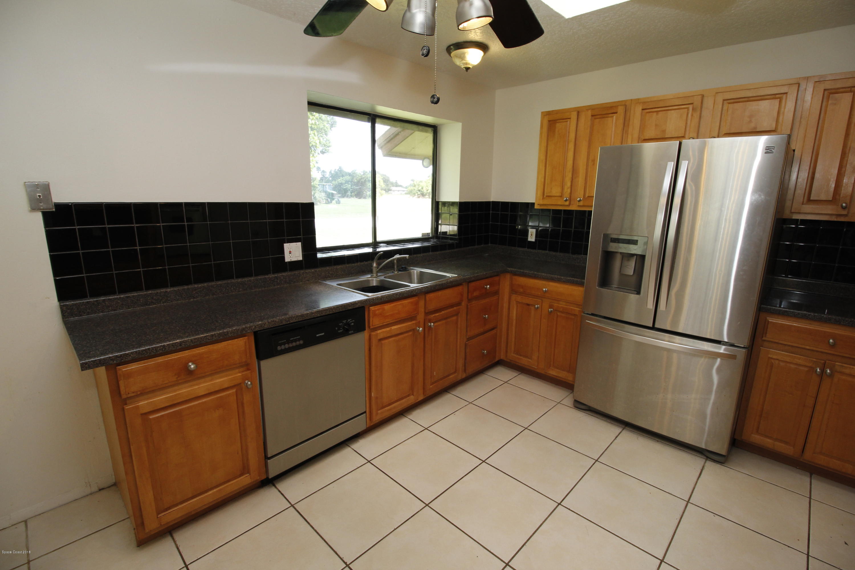 1302 Cherry Hills Road Northeast Palm Bay, FL 32905 - Photo 12 of 24 a kitchen with stainless steel appliances granite countertop a refrigerator a sink a stove and island