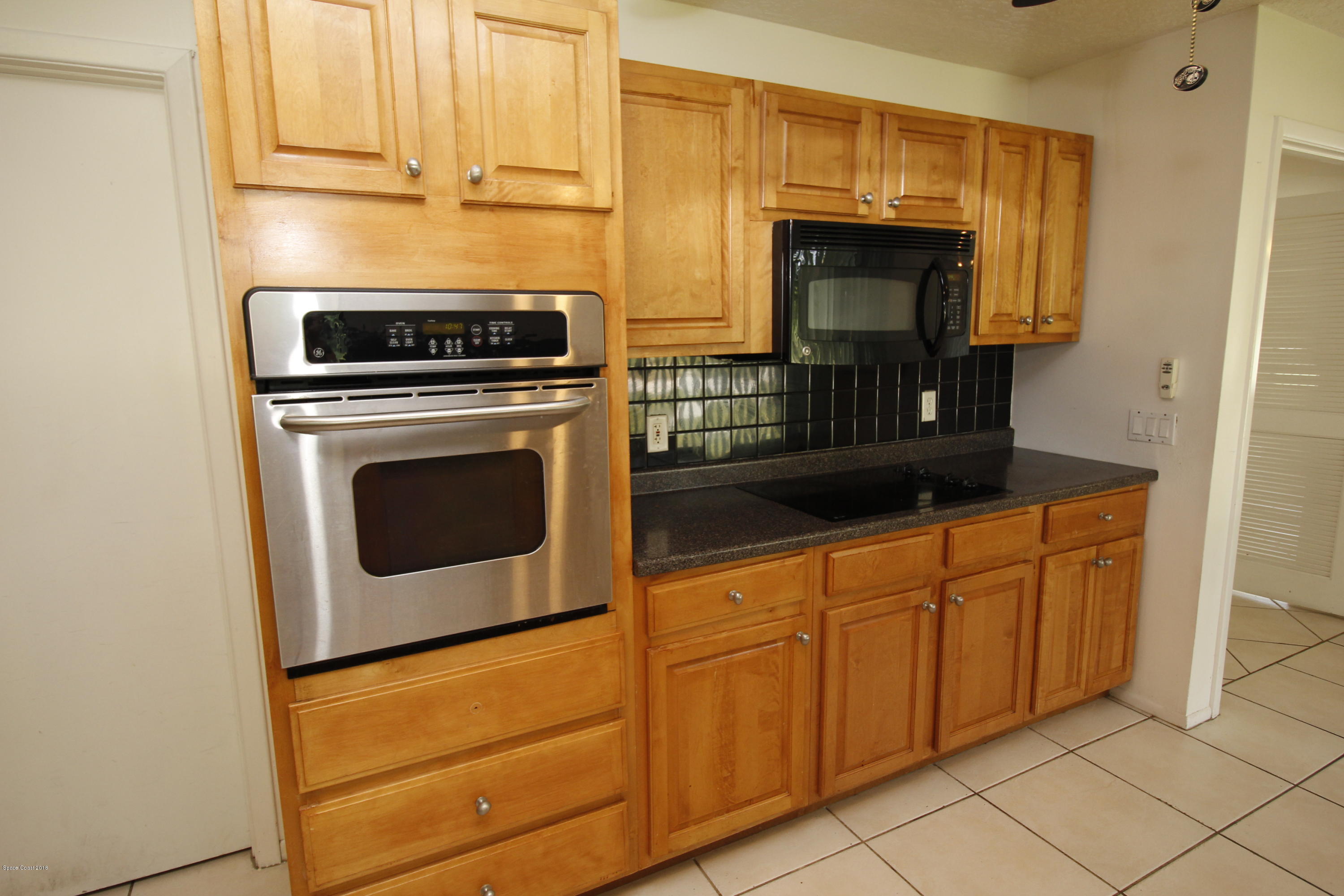 1302 Cherry Hills Road Northeast Palm Bay, FL 32905 - Photo 13 of 24 a kitchen with granite countertop cabinets and steel stainless steel appliances