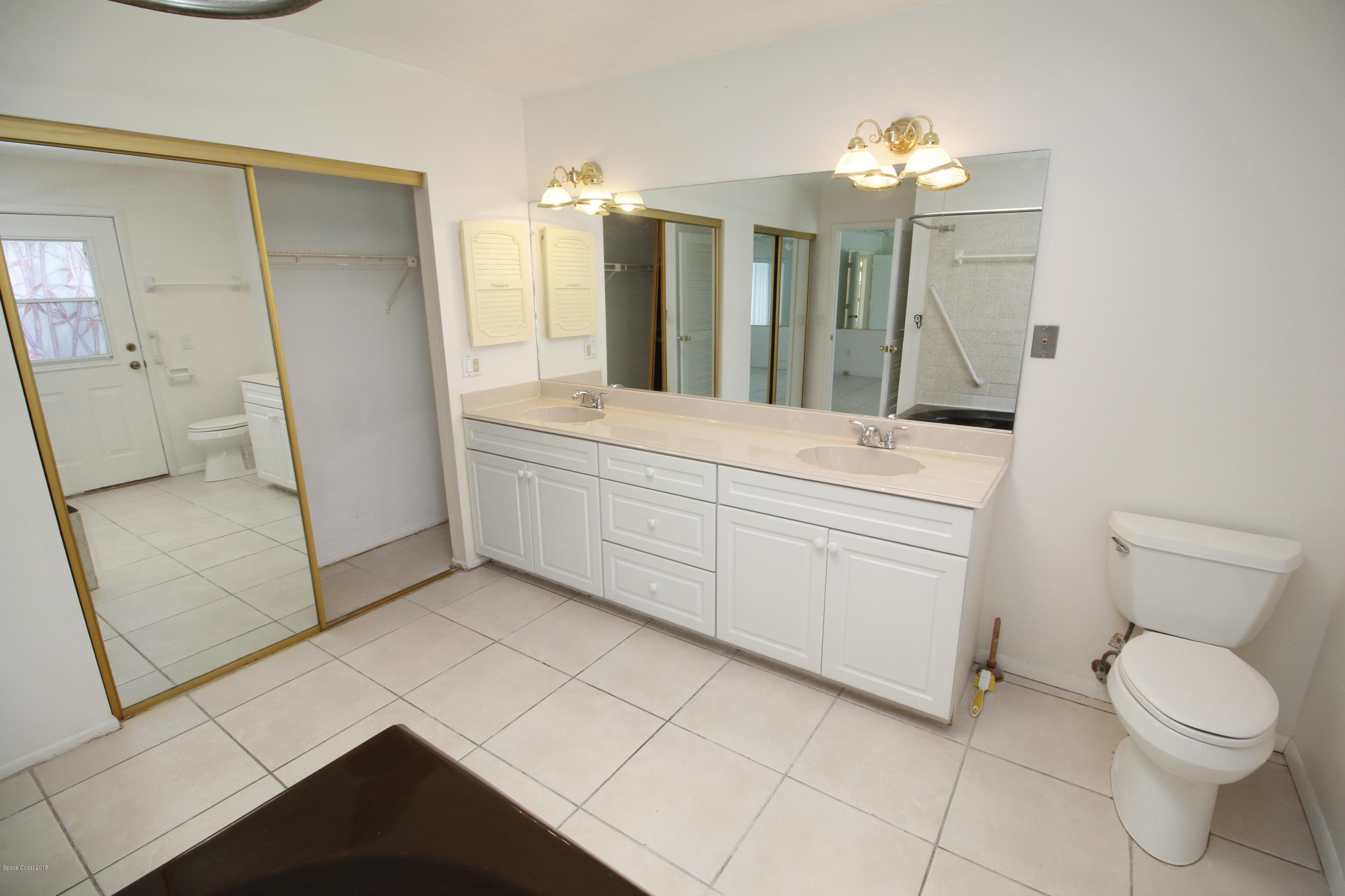 1302 Cherry Hills Road Northeast Palm Bay, FL 32905 - Photo 17 of 24 a bathroom with a sink a toilet and a mirror