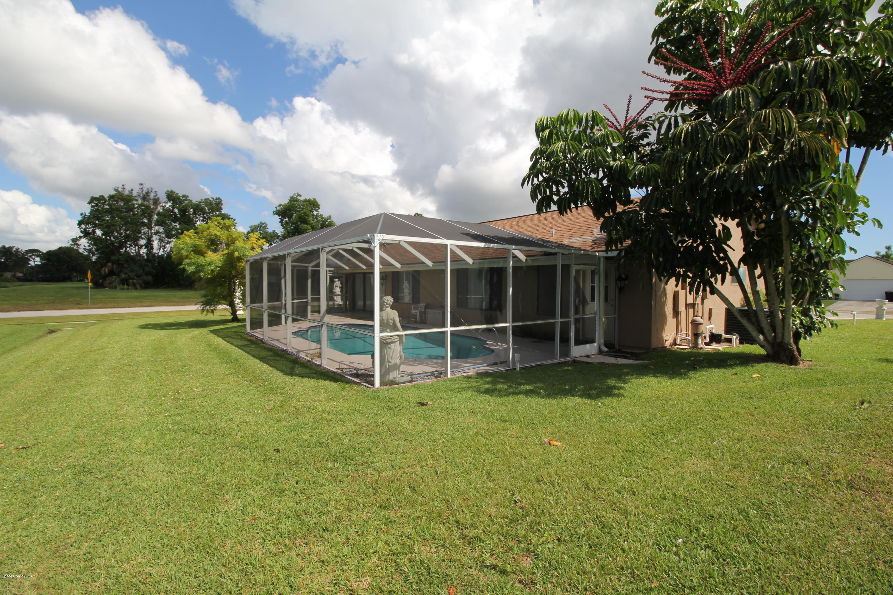 1302 Cherry Hills Road Northeast Palm Bay, FL 32905 - Photo 8 of 24 a view of a house with a big yard and large trees
