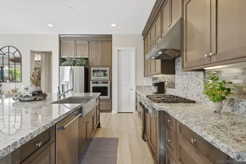 a kitchen with stainless steel appliances granite countertop a sink stove and refrigerator