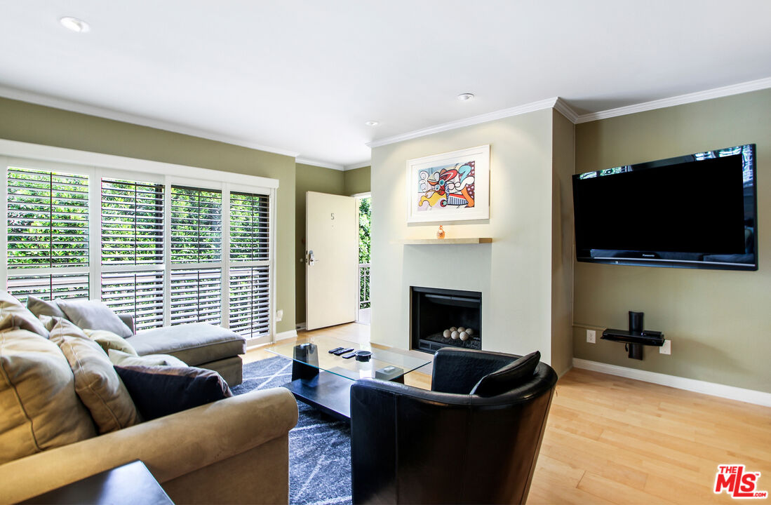 10671 Wilkins Avenue, Unit 5 Los Angeles, CA 90024 - Photo 1 of 28 a living room with furniture a flat screen tv and a fireplace