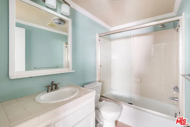 a bathroom with a sink mirror toilet and shower