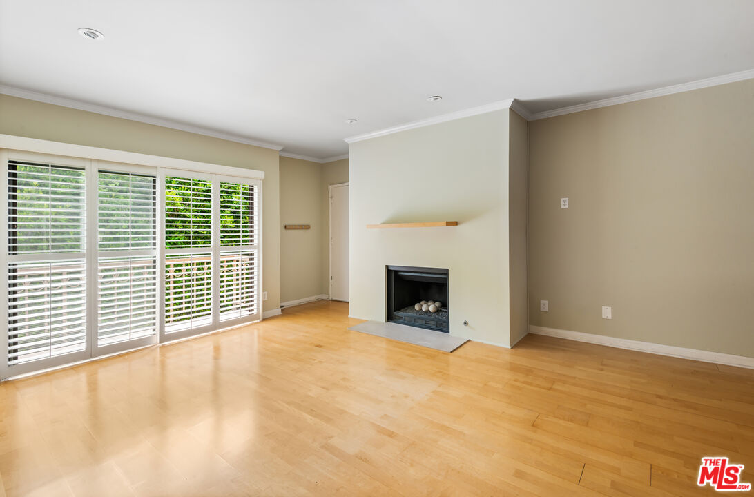 10671 Wilkins Avenue, Unit 5 Los Angeles, CA 90024 - Photo 3 of 28 a view of empty room with wooden floor and fireplace