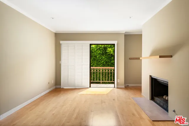 a view of an empty room with a fireplace and a window