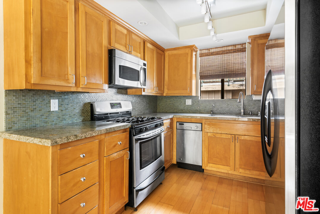 10671 Wilkins Avenue, Unit 5 Los Angeles, CA 90024 - Photo 10 of 28 a kitchen with stainless steel appliances granite countertop a stove a sink and a refrigerator