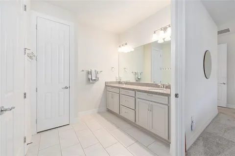 a spacious bathroom with a shower a sink and a mirror