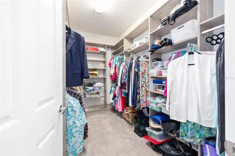 a view of walk in closet with clothes