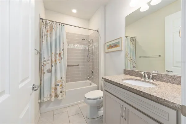 a bathroom with a granite countertop sink a toilet and shower