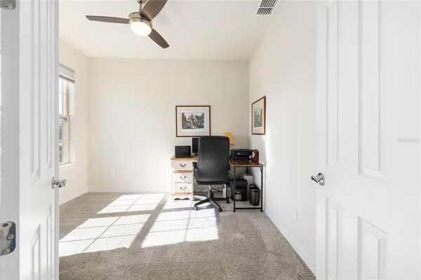 a view of a workspace with furniture and a window