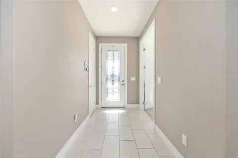 a view of a hallway with a chandelier fan and windows