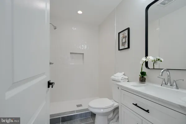 a bathroom with a sink mirror vanity and toilet