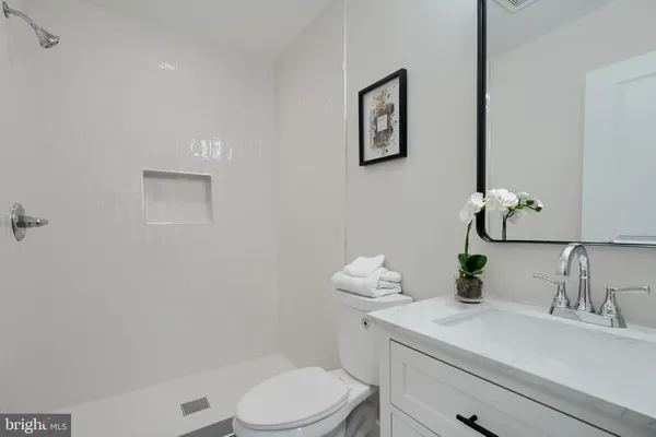 a bathroom with a sink a toilet and mirror