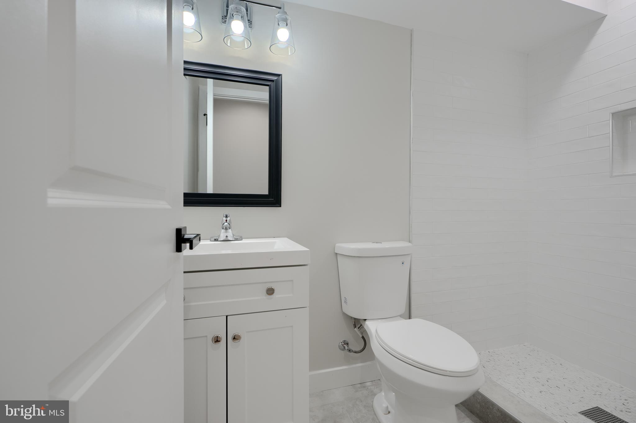602 South Streeper Street Baltimore, MD 21224 - Photo 22 of 31 a bathroom with a toilet sink vanity and mirror