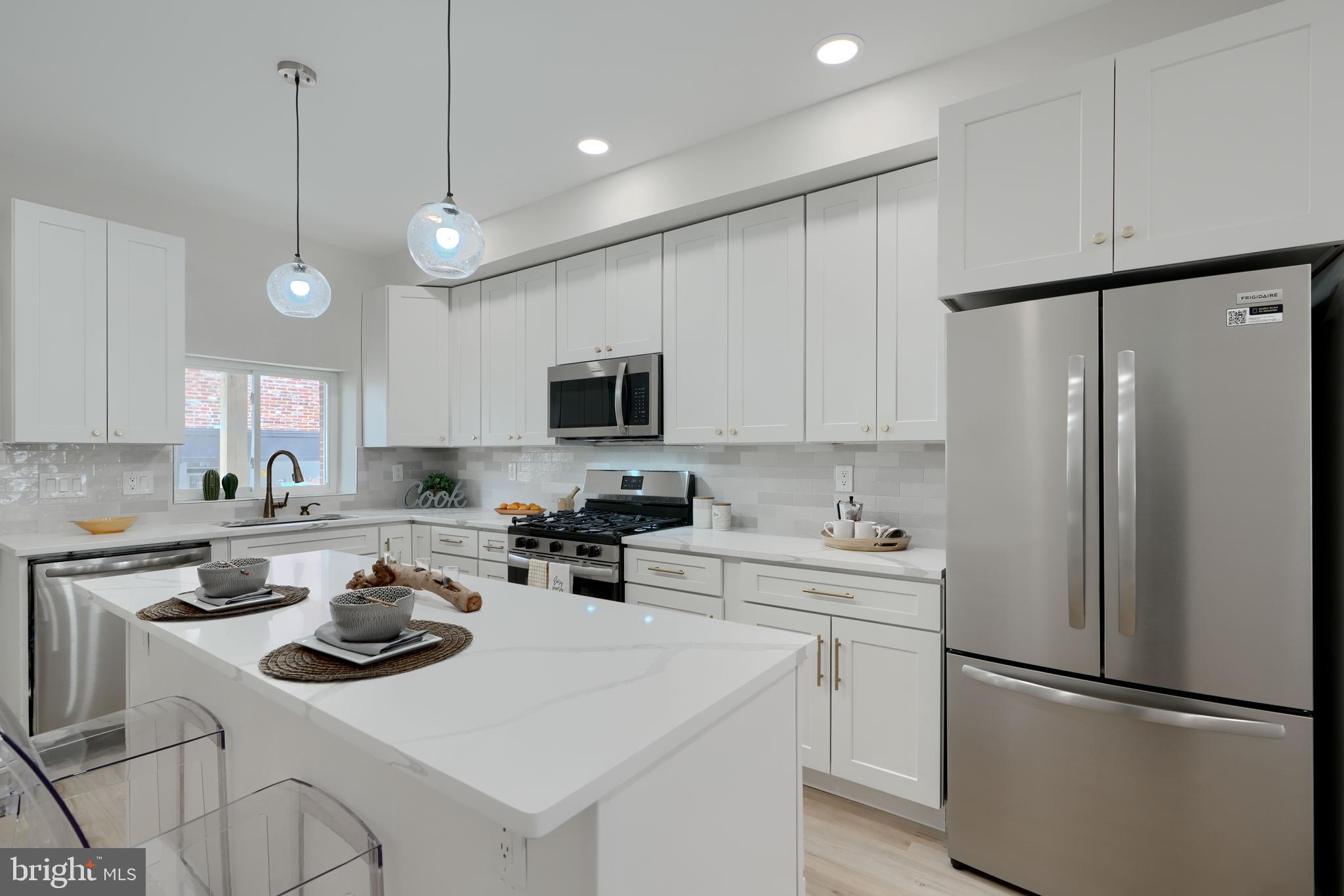 602 South Streeper Street Baltimore, MD 21224 - Photo 6 of 31 a kitchen with a sink a stove a refrigerator and white cabinets
