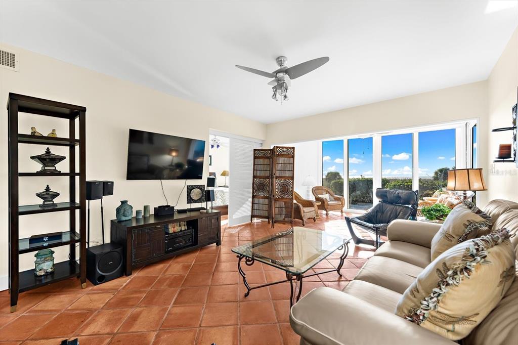 5000 Gasparilla Road, Unit 13A Boca Grande, FL 33921 - Photo 18 of 61 a living room with furniture a flat screen tv and a floor to ceiling window