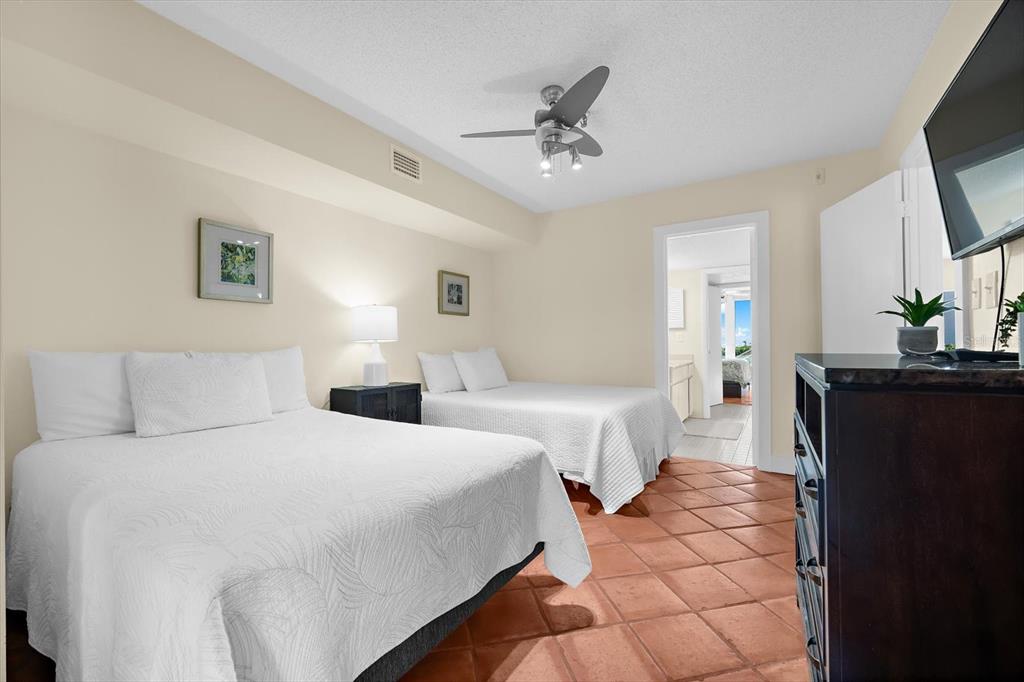 5000 Gasparilla Road, Unit 13A Boca Grande, FL 33921 - Photo 33 of 61 a spacious bedroom with two beds and a flat screen tv