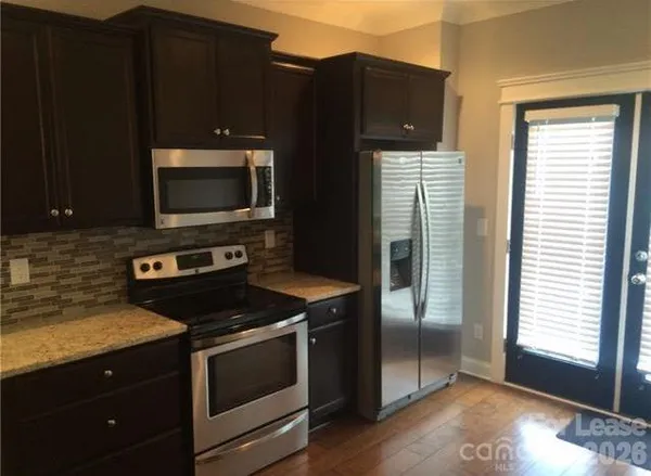 a kitchen with granite countertop wooden cabinets and black appliances