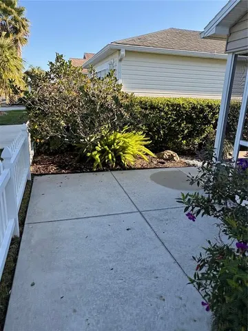 a view of a house with a small yard and potted plants