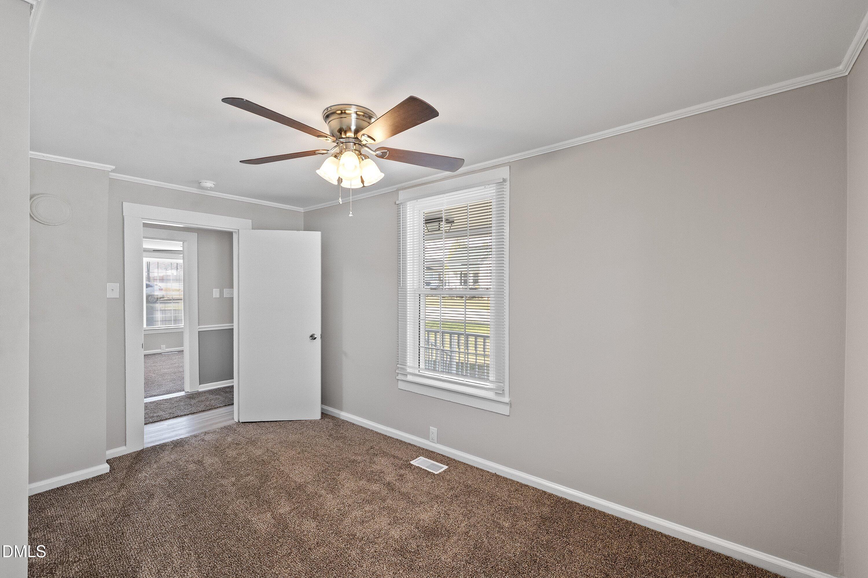 105 East I Street Erwin, NC 28339 - Photo 12 of 39 an empty room with windows and fan