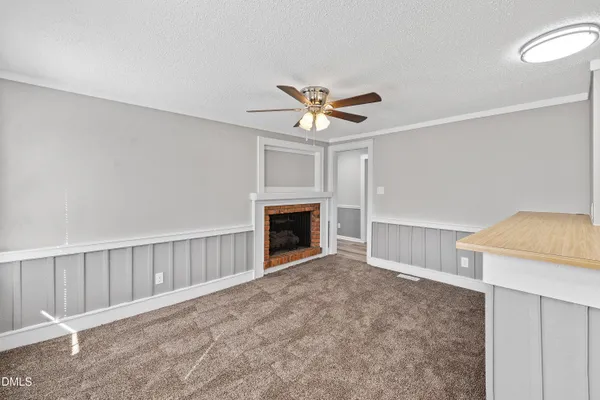 a view of a livingroom with a fireplace and a chandelier fan