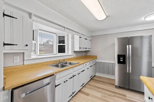 a kitchen with stainless steel appliances granite countertop a sink and a refrigerator