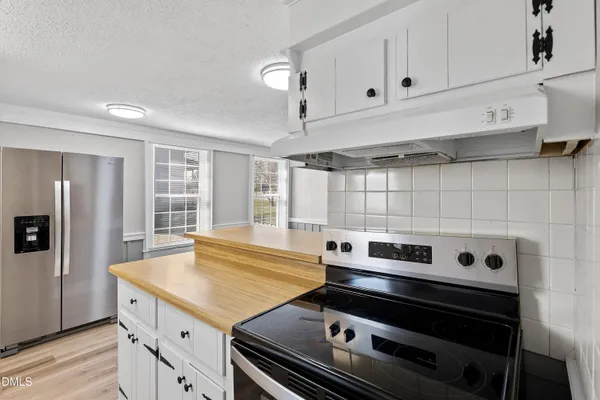 a stove top oven sitting inside of a kitchen