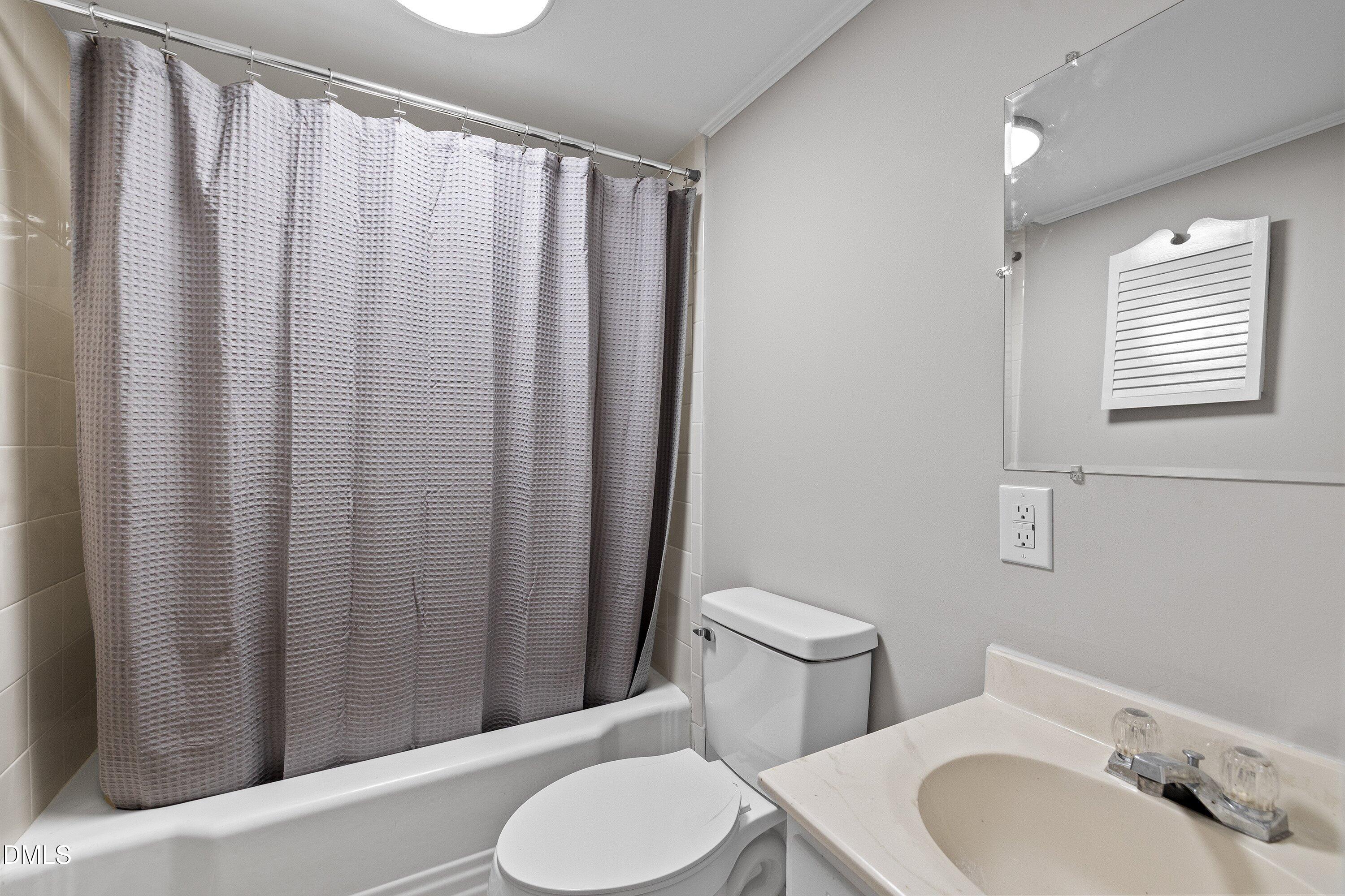 105 East I Street Erwin, NC 28339 - Photo 26 of 39 a white toilet sitting next to a bathroom sink