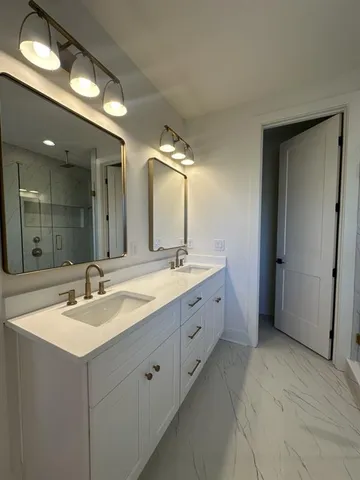 a spacious bathroom with double vanity a sink and a mirror