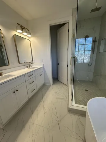 a bathroom with a double vanity sink toilet and shower