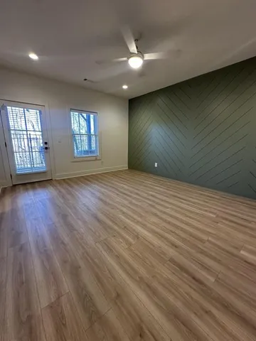 a view of an empty room with wooden floor
