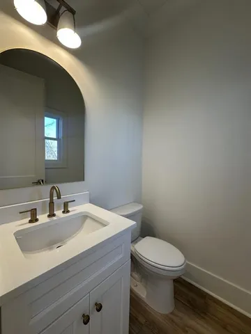 a bathroom with a toilet a sink and mirror