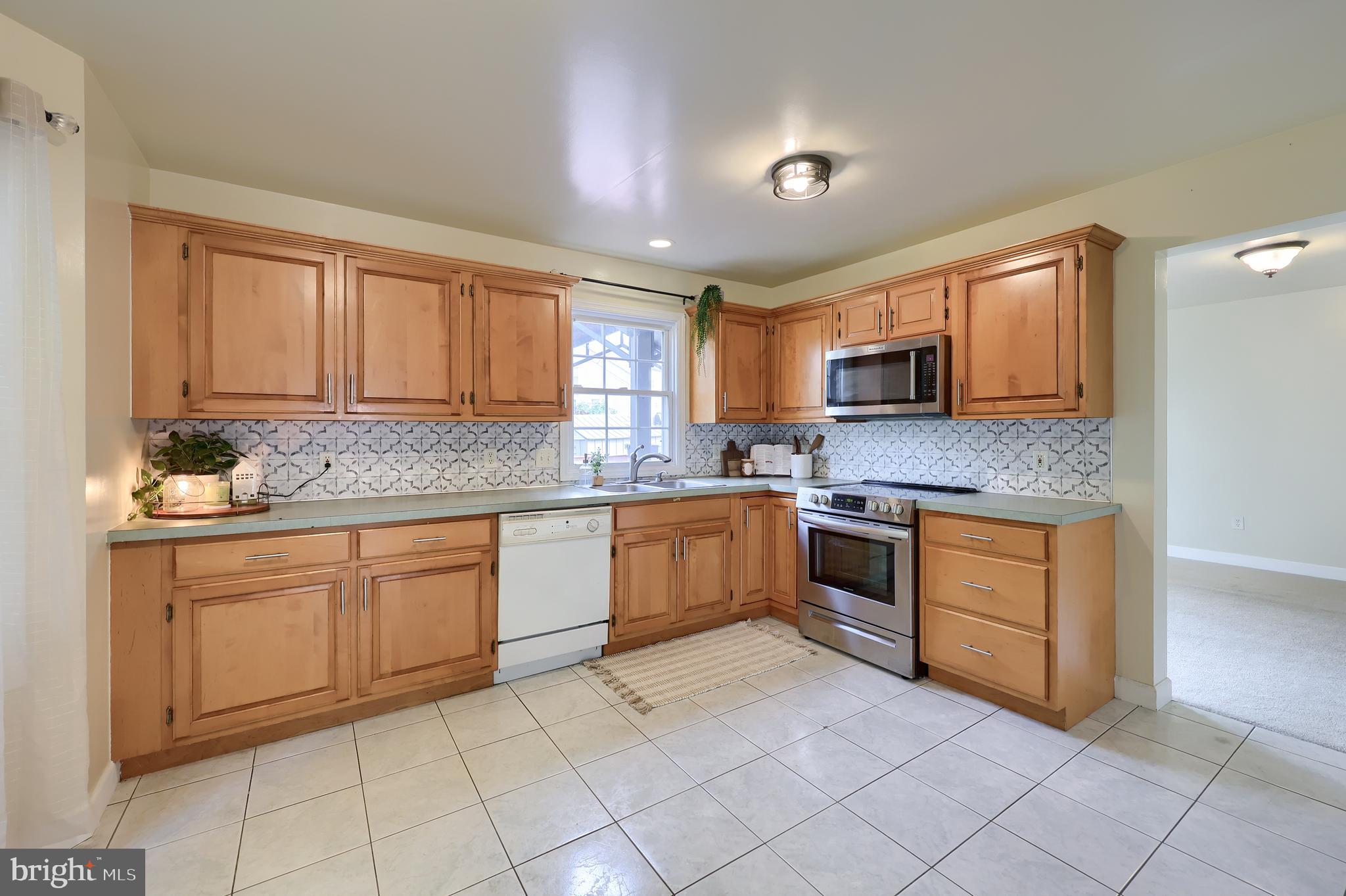 148 Michigan Drive Sinking Spring, PA 19608 - Photo 20 of 50 a large kitchen with granite countertop a stove a sink dishwasher and a microwave oven with white cabinets