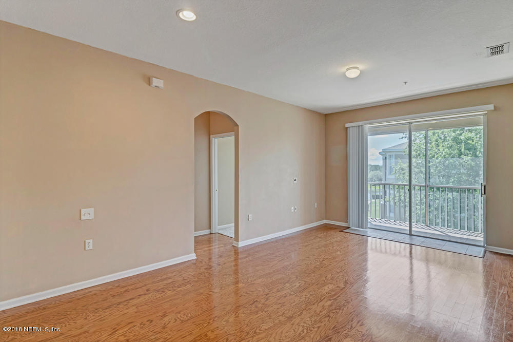 7990 Baymeadows Road East, Unit 211 Jacksonville, FL 32256 - Photo 9 of 21 an empty room with wooden floor and sliding door