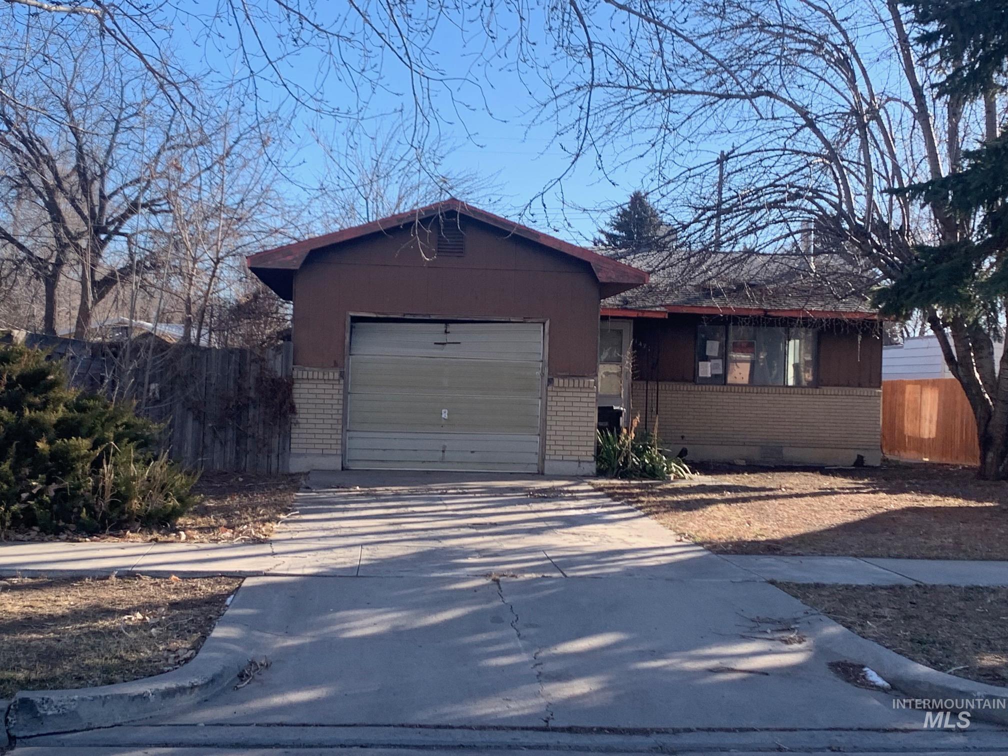 Single story home with brick siding, driveway, and an attached garage