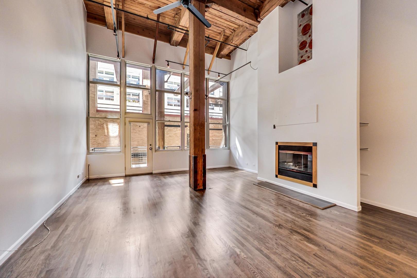 1000 West Washington Boulevard, Unit 130 Chicago, IL 60607 - Photo 11 of 47 a view of an empty room with wooden floor and a window